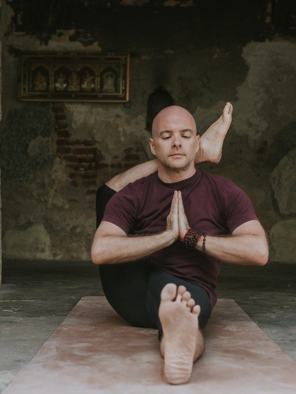 Alan in Eka Pada Sirsasana A (Posizione con Una Gamba Dietro la Testa A), posizione avanzata in Ashtanga Yoga (Serie Intermedia - Nadi Shodhana)