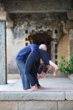 Alan che sostiene lo studente nel movimento di drop back e catching, una tecnica chiave di piegamento all'indietro nell'Ashtanga