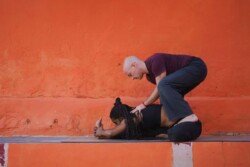 Alan che guida lo studente più in profondità in Janu Sirsasana A (Piegamento in Avanti Testa al Ginocchio) nella pratica Ashtanga (Prima Serie - Yoga Chikitsa).