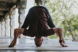 Alan in Prasarita Padottanasana D (Posizione del Piegamento in Avanti con Gambe Larghe D), variante in Ashtanga Yoga (Prima Serie - Yoga Chikitsa)